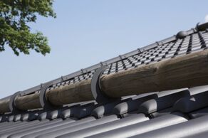 Specjalne systemowe dachówki z uchwytami pod stopnie kominiarskie lub bariery przeciwśniegowe ułatwiają estetyczne i szczelne wykonanie pokrycia dachowego (fot. CREATON)